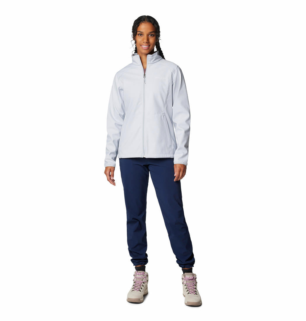 A woman wearing a grey full-zip Columbia softshell jacket with adjustable cuffs and hem, and zippered pockets on the sides.